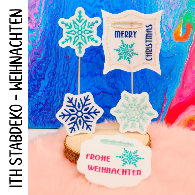 Stickdatei Set Weihnachts-Stabdesigns, Foto zeigt 5 Designs, präsentiert auf Holzscheibe, die auf orangem Fell liegt. 2 mal mit Einstecköffnung: 1 mal Schnörkelrahmen, Eiskristall, Aufschrift "Frohe Weihnachten"; 1 mal Rahmen mit ausgezogenen Ecken