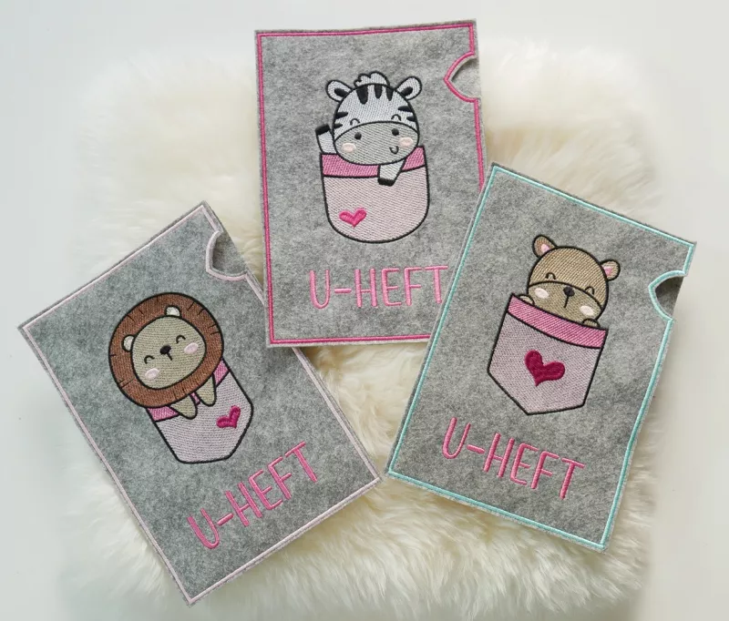 U-Heft-Hüllen mit Zebra, Löwe und Bärchen in rosa.