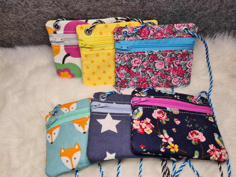 Stickdatei Set BLANKO ITH Taschen im Querformat mit unterschiedlich farbigem Reißverschluss in der Front oben, darüber links und rechts Öse mit Kordeldurchzug. Foto zeigt auf Fell präsentiert 6 Designs mit unterschiedlich bedruckten Stoffen (buntes Apfelm Stickdatei Set BLANKO ITH Taschen im Querformat mit unterschiedlich farbigem Reißverschluss in der Front oben, darüber links und rechts Öse mit Kordeldurchzug. Foto zeigt auf Fell präsentiert 6 Designs mit unterschiedlich bedruckten Stoffen (buntes Apfelm