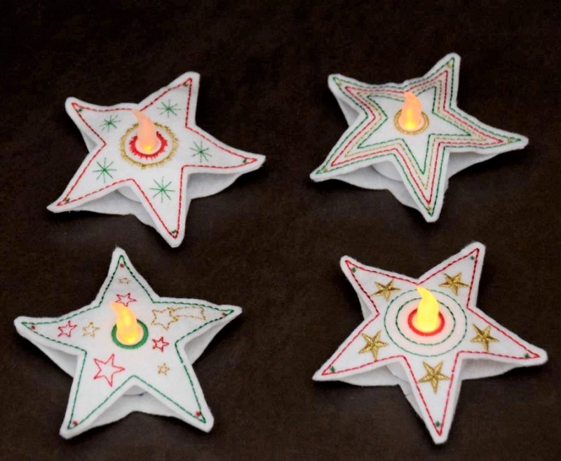 Stickdatei Set Christmas Lights (div. Rahmengrößen), Foto zeigt als LED-Cover in Sternformat 4 weiße fünfzackige Filz-Sterne, leicht divers bunt bestickt. Jeder mit mittig 1 Öffnung, in die je ein leuchtendes LED eingesteckt ist.