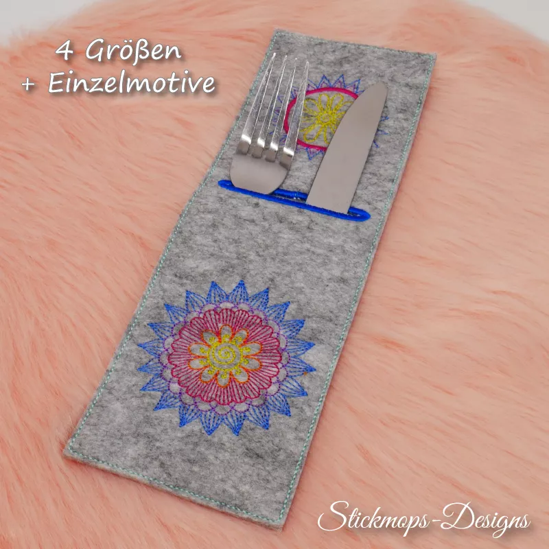 Stickdatei Set Mandala-Bestecktaschen + Einzelmotive, Foto mit auf orangefarbenem Fell liegender Hochkant-Tasche, befüllt mit Messer und Gabel, Schrifthinweis: 4 Größen + Einzelmotive. Einstecköffnung im eher oberen Teil, blau umrandet, eher hellgrauer Fi