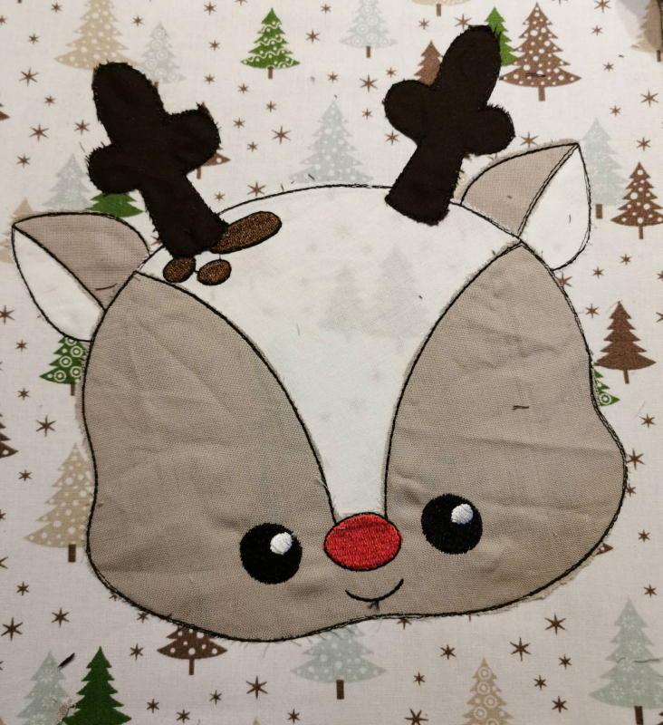 Stickdatei Set Christmas Faces Doodle-Applikationen. Foto von Applikation eines Rentierkopfes, aufgebracht auf gemusterten Stoff mit Weihnachtsdruck. Stickdatei Set Christmas Faces Doodle-Applikationen. Foto von Applikation eines Rentierkopfes, aufgebracht auf gemusterten Stoff mit Weihnachtsdruck.