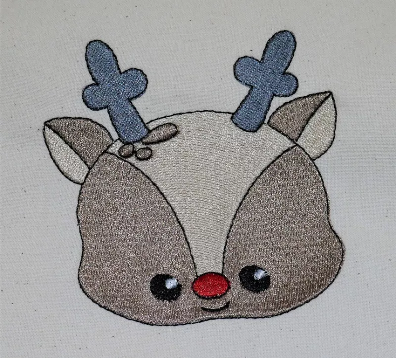 Stickdatei Set Christmas Faces Vollstick, Foto zeigt Motiv eines Rehkitzkopfes (blau-braun-beige-rot) auf hellem Stoff.