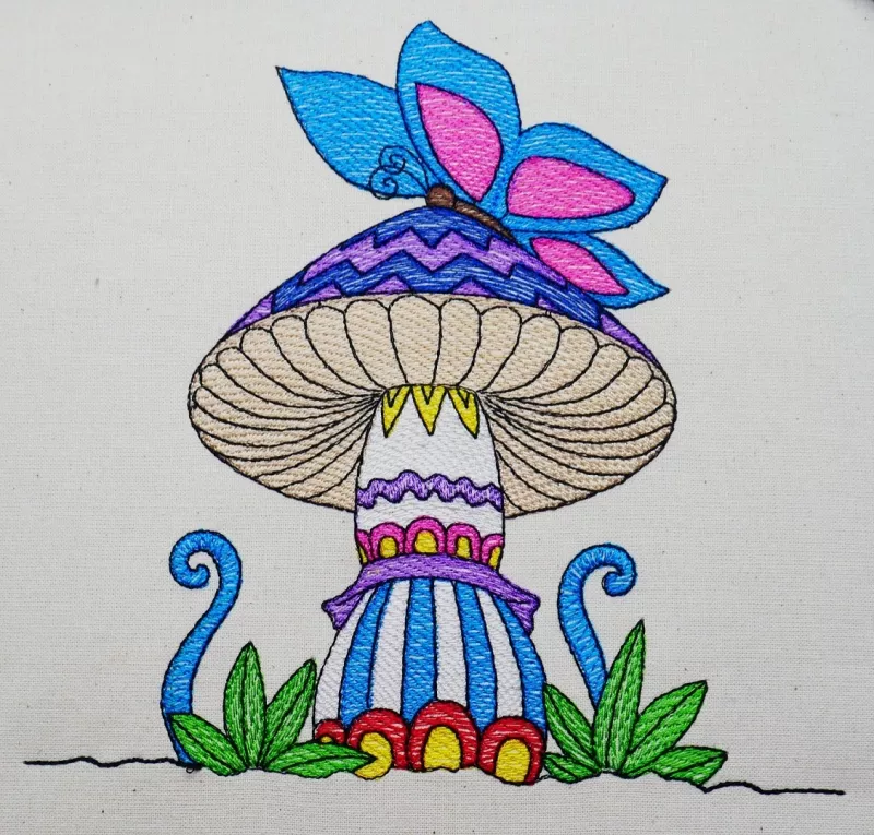 Stickdatei mit zwei Pilzen auf einer Wiese mit Schmetterling.