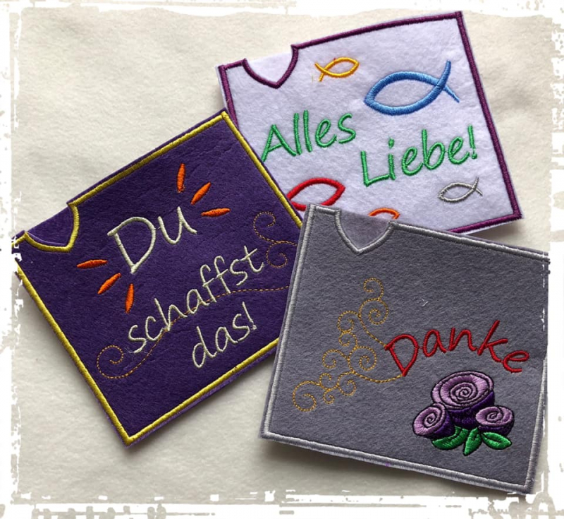 Stickdatei Set ITH Motivhüllen für viele Anlässe für Schokolade, Gutscheine u.a., Foto zeigt 3 quadratische Hüllen in dunkelgrau, violett und lila. Diverse Bestickungen und Schriftzüge ("Du schaffst das"; "Danke"; "Alles Liebe").