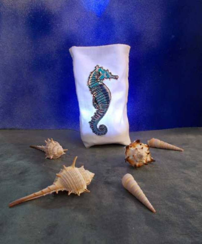 Stickdatei Set ITH Lichtbeutel Unterwasserwelt, Foto mit Lichtbeutel aus hellem Stoff, davor Meeresdekoartikel. Bestickung: Buntes Seepferdchen. Stickdatei Set ITH Lichtbeutel Unterwasserwelt, Foto mit Lichtbeutel aus hellem Stoff, davor Meeresdekoartikel. Bestickung: Buntes Seepferdchen.