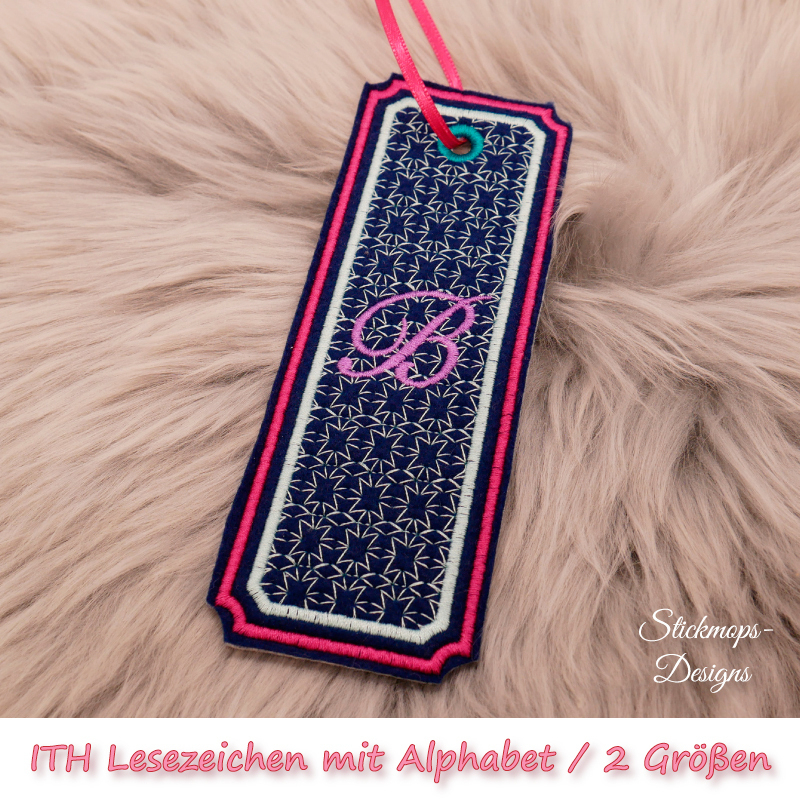 (Osterkalender-Türchen 6A) Stickdatei Set ITH Lesezeichen mit Alphabet in 2 Größen, Foto zeigt am Bändchen garngeöstes längliches Lesezeichen, rechteckig, mit eingekerbten Ecken. Schwarz, Bestickung beige-rot, filigranes Muster, in pink schnörkeliger Buch