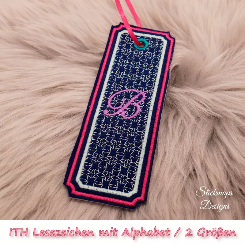 (Osterkalender-Türchen 6A) Stickdatei Set ITH Lesezeichen mit Alphabet in 2 Größen, Foto zeigt am Bändchen garngeöstes längliches Lesezeichen, rechteckig, mit eingekerbten Ecken. Schwarz, Bestickung beige-rot, filigranes Muster, in pink schnörkeliger Buch