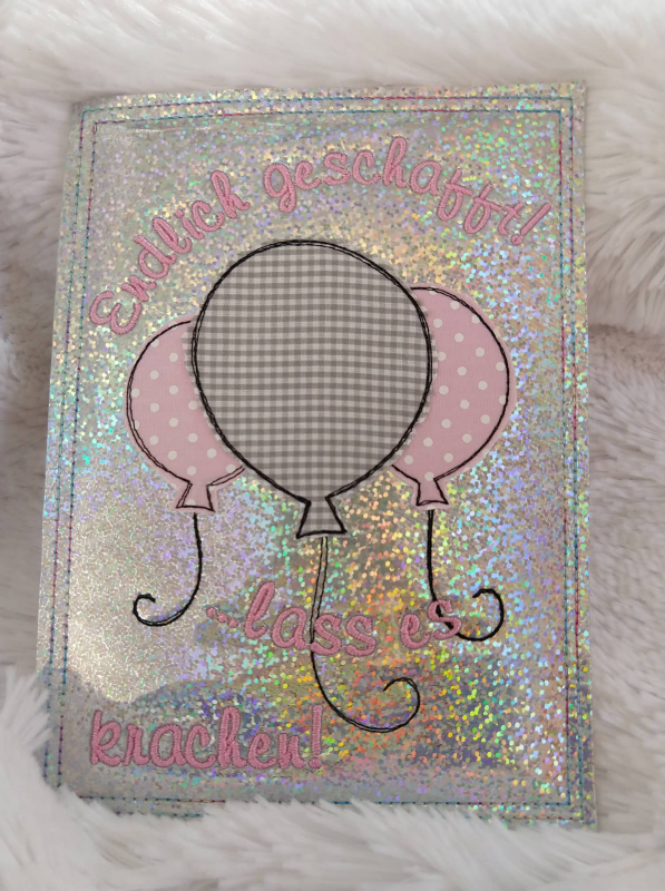 Stickdatei Set ITH Glückwunschkarten inkl. Abwandlung zur Geschenktasche (div. Rahmengr.), Foto von Karte, auf Felluntergrund liegend. Karte mit Applikation dreier Luftballons (2 unterschiedliche Stoffe) auf Glitzerhintergrund. Bestickung mit Schriftzug "