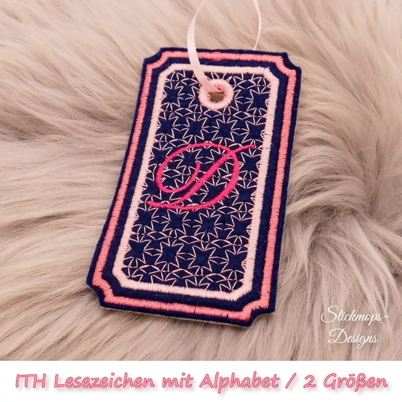 (Osterkalender-Türchen 6A) Stickdatei Set ITH Lesezeichen mit Alphabet in 2 Größen, Foto zeigt am Bändchen garngeöstes Lesezeichen, rechteckig, mit eingekerbten Ecken. Schwarz, Bestickung rosa-apricot, filigranes Muster, in rot schnörkeliger Buchstabe "D"