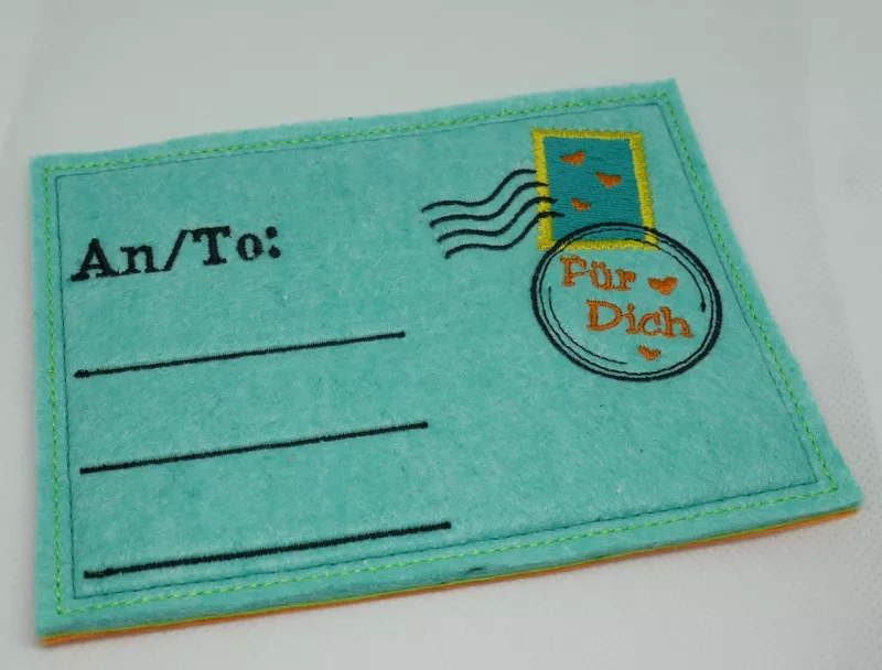 Stickdatei Set ITH Postkarten inkl. Abwandlung zur Geschenktasche (div. Größen), Foto zeigt 1 Karten in türkis. Links bestickt mit "An/To:", darunter 3 Linien Für Adresse. Rechts gestickte Briefmarke mit 2 Stempeln, darin Schriftzug "Für dich".