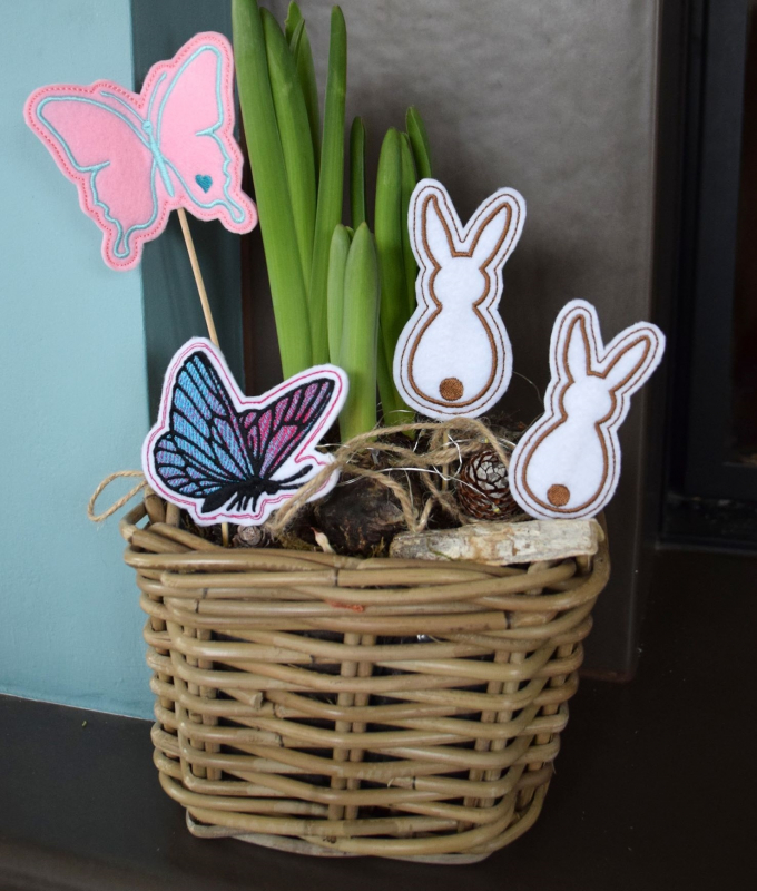 Stickdatei Set ITH Frühlings-Stabdesigns, Foto mit 4 Designstäben, in einem Korb mit Pflanzentrieb steckend. Diverse Farben; Motive: Hasen, Schmetterlinge. Stickdatei Set ITH Frühlings-Stabdesigns, Foto mit 4 Designstäben, in einem Korb mit Pflanzentrieb steckend. Diverse Farben; Motive: Hasen, Schmetterlinge.