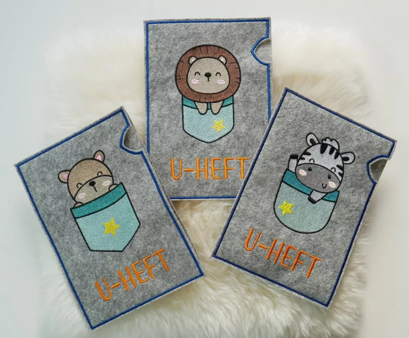 U-Heft-Hüllen mit Zebra, Löwe und Bärchen in türkis.