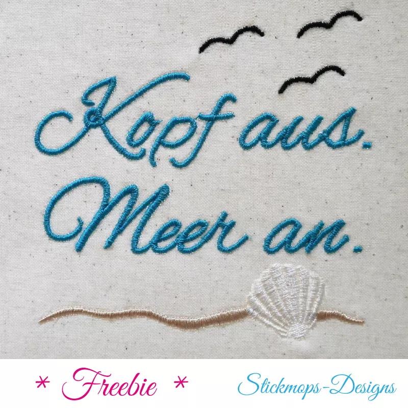 Freebie Stickdatei Kopf aus Meer an, Foto einer Ausfertigung auf hellem Stoffuntergrund. Blauer Schreibschriftzug "Kopf aus. Meer an.", 3 schwarze stilisierte fliegende Vögel, goldfarbene Wellenlinie, hellglänzende Muschel.