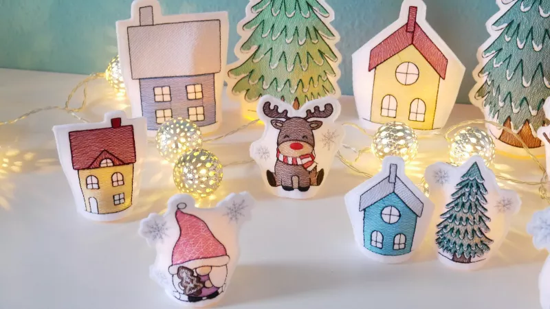 Stickdatei Set ITH LED Cover Winterdorf mit Gnomen, Häusern und Rentier.